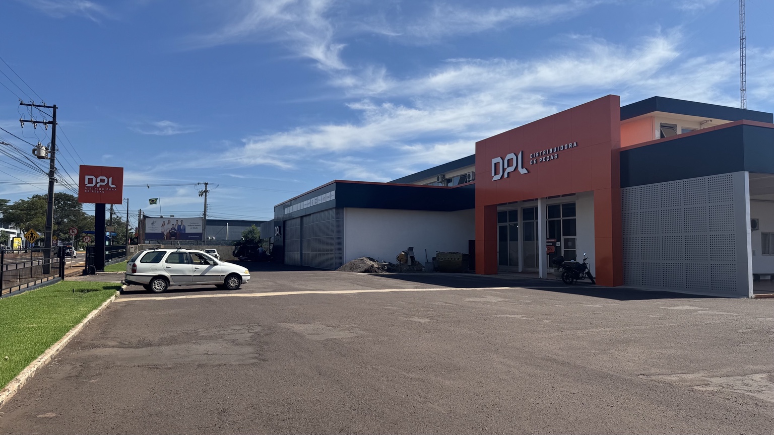 Vista intermediária da fachada DPL com totem e portal de entrada — projeto MIDIAFIX